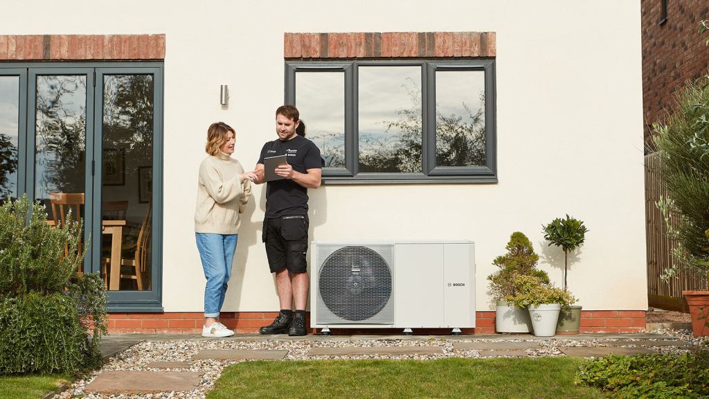 Heating installer explaining a Bosch air source heat pump system to a homeowner